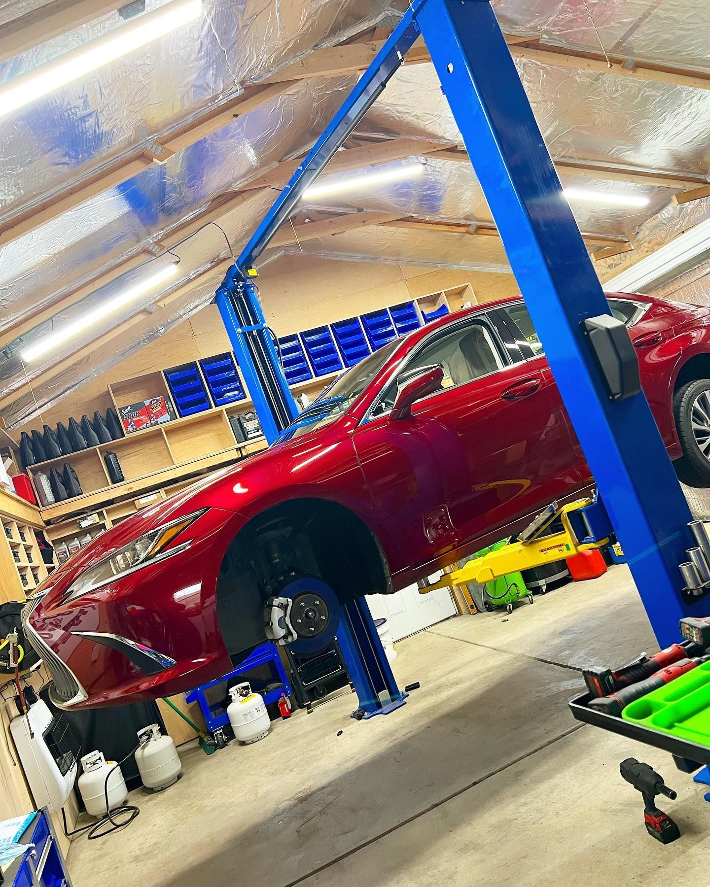 Red SUV Lifted Inside Garage | PDub’s Garage LLC