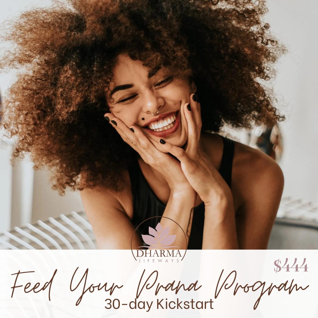 A woman with curly hair is smiling with her hands on her face.