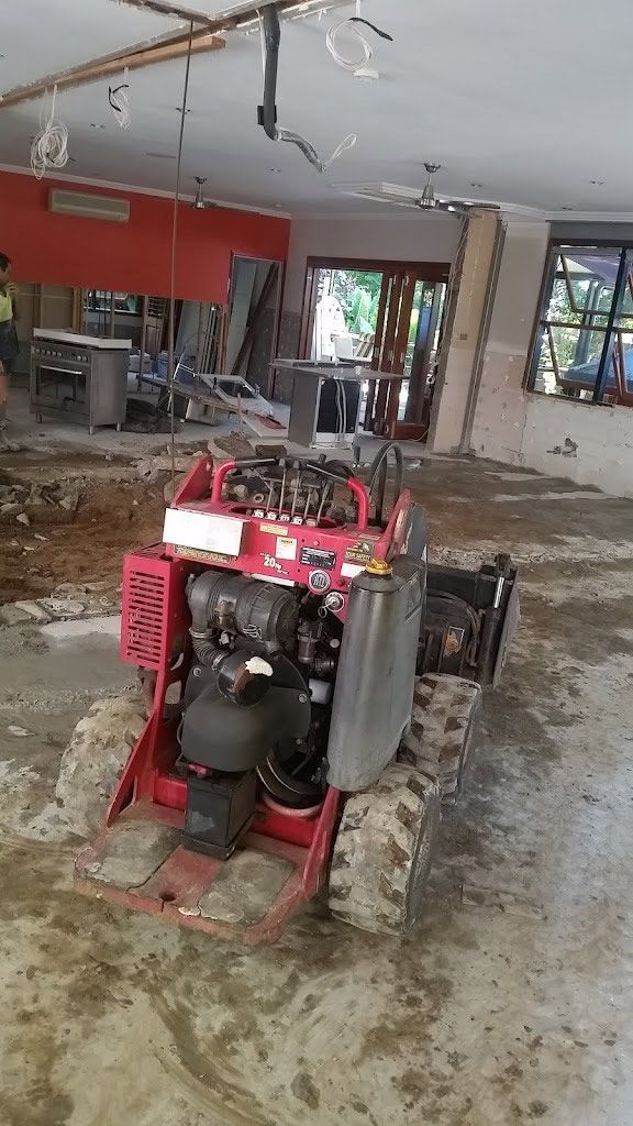 A Red Tractor Is Sitting In The Middle Of A Building Under Construction — Absolute Dingo Services in White Rock, QLD
