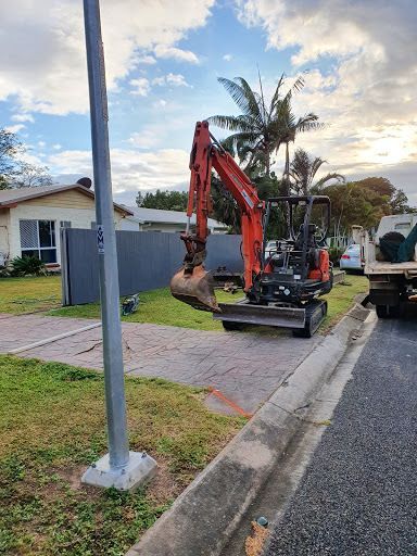 A Small Excavator Is Parked On The Side Of The Road — Absolute Dingo Services in White Rock, QLD