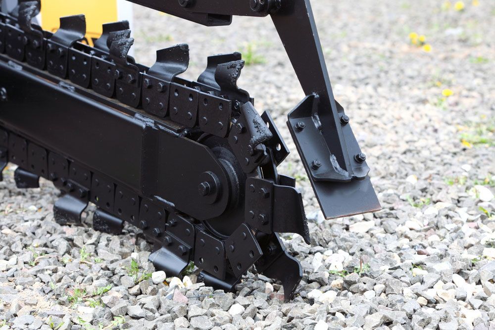 A Black Chainsaw Is Sitting On A Pile Of Gravel — Absolute Dingo Services in White Rock, QLD