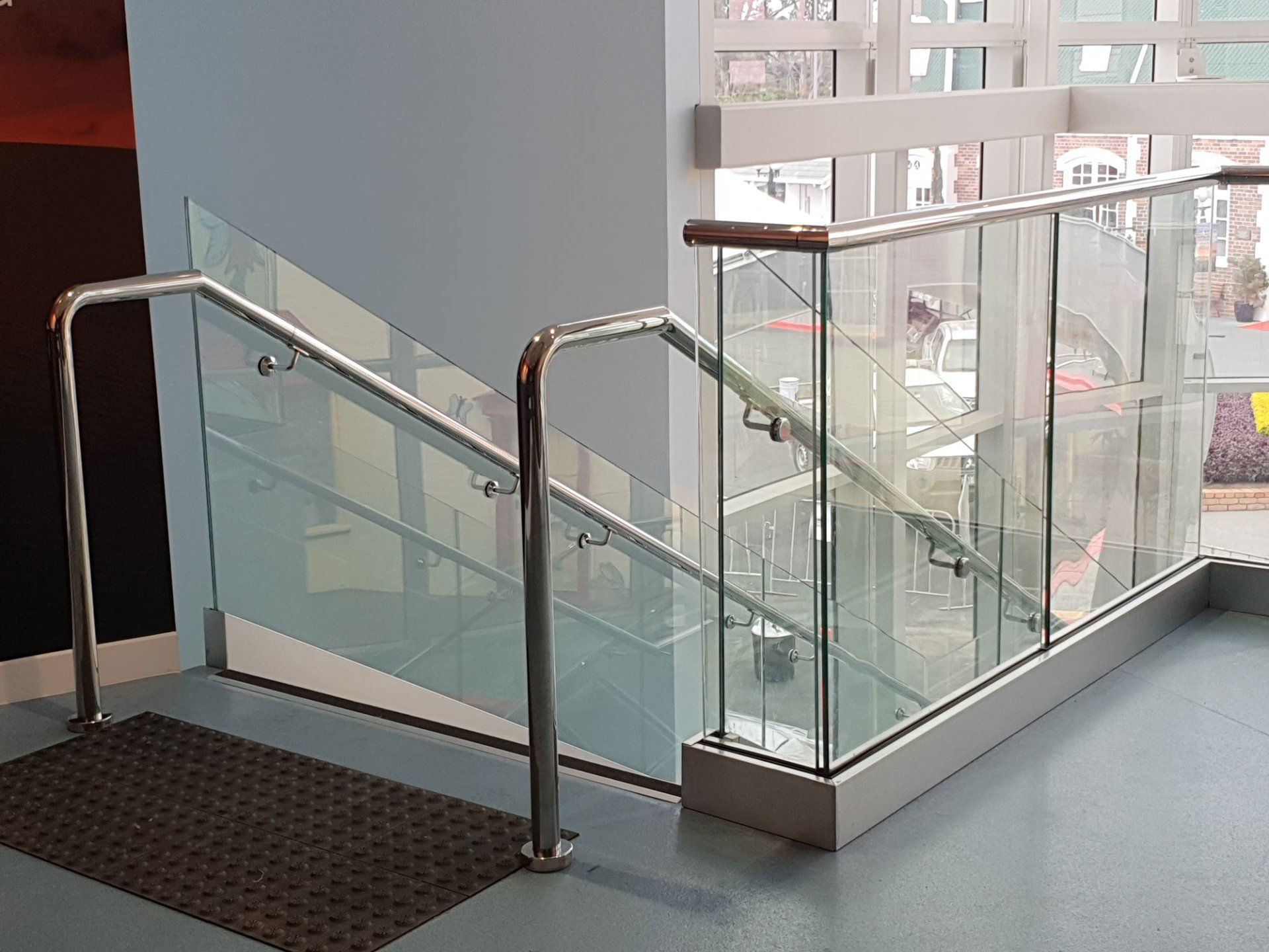Staircase with glass panels and metal handrails inside a building.