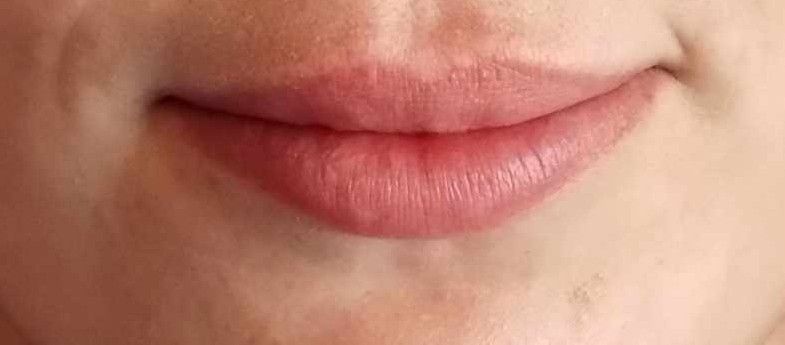 A close up of a woman 's lips with pink lipstick.