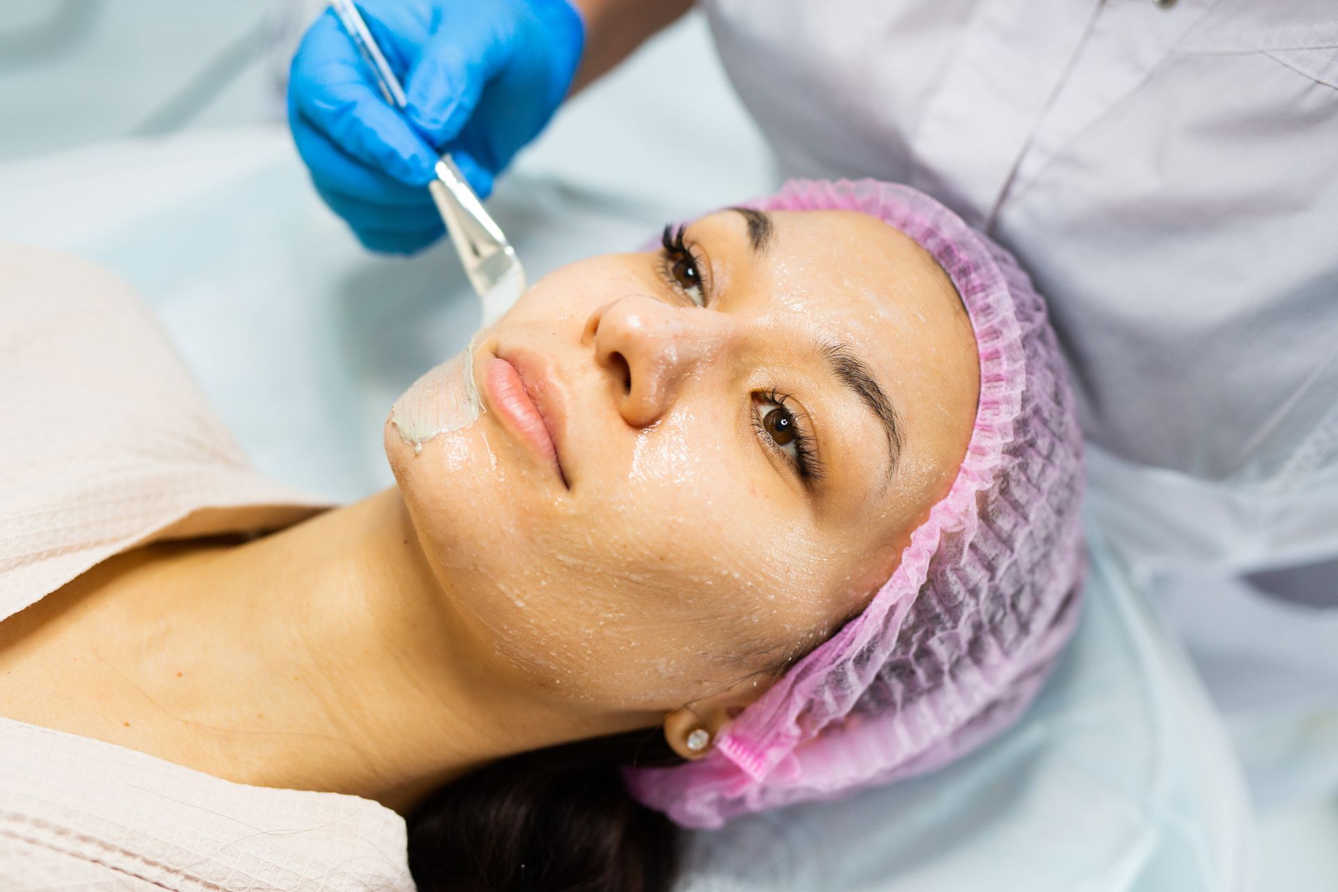 A woman is getting a facial treatment at a beauty salon.