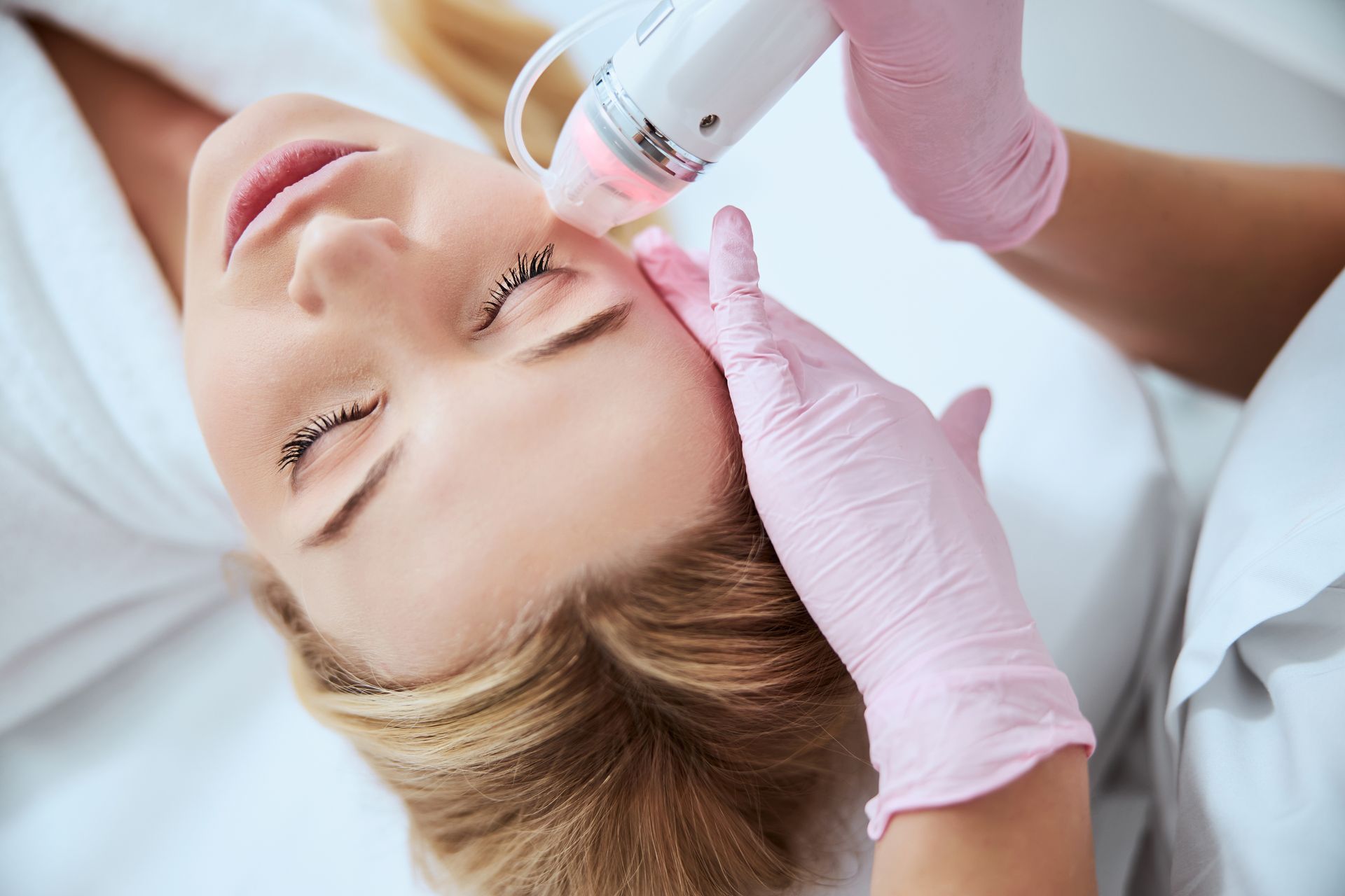 A woman is getting a facial treatment at a beauty salon.