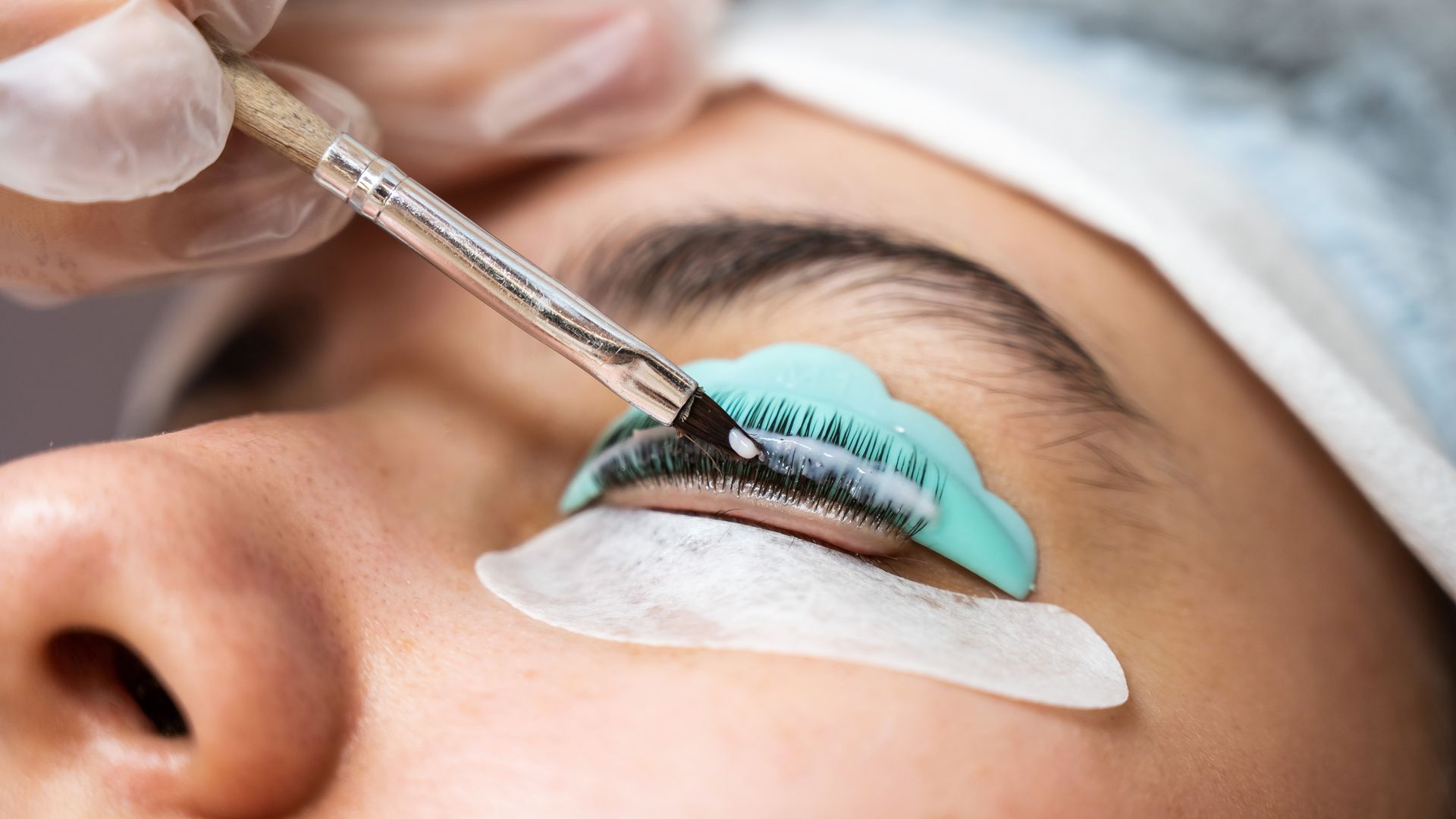 A woman is getting her eyelashes done at a beauty salon.