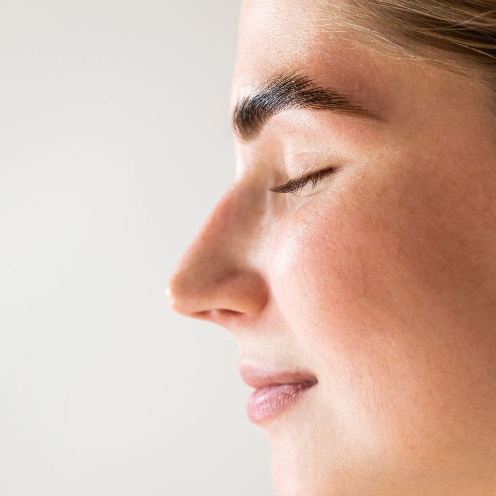 A close up of a woman 's face with her eyes closed.