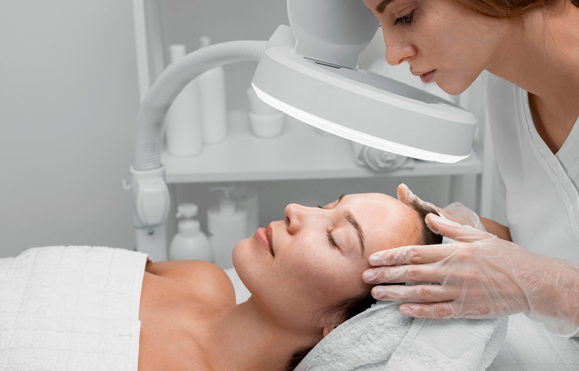 A woman is getting a facial treatment at a beauty salon.