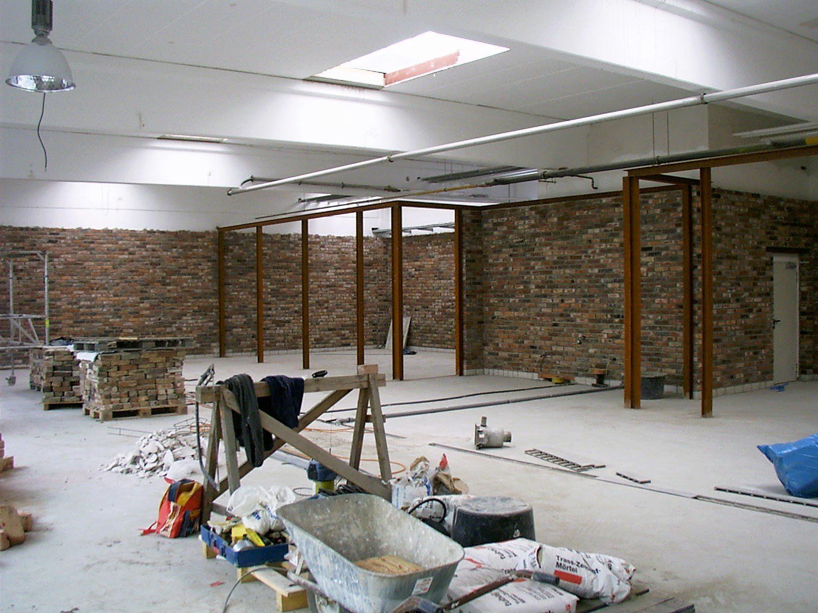 Ein leerer Raum mit Ziegelwänden und einer Schubkarre