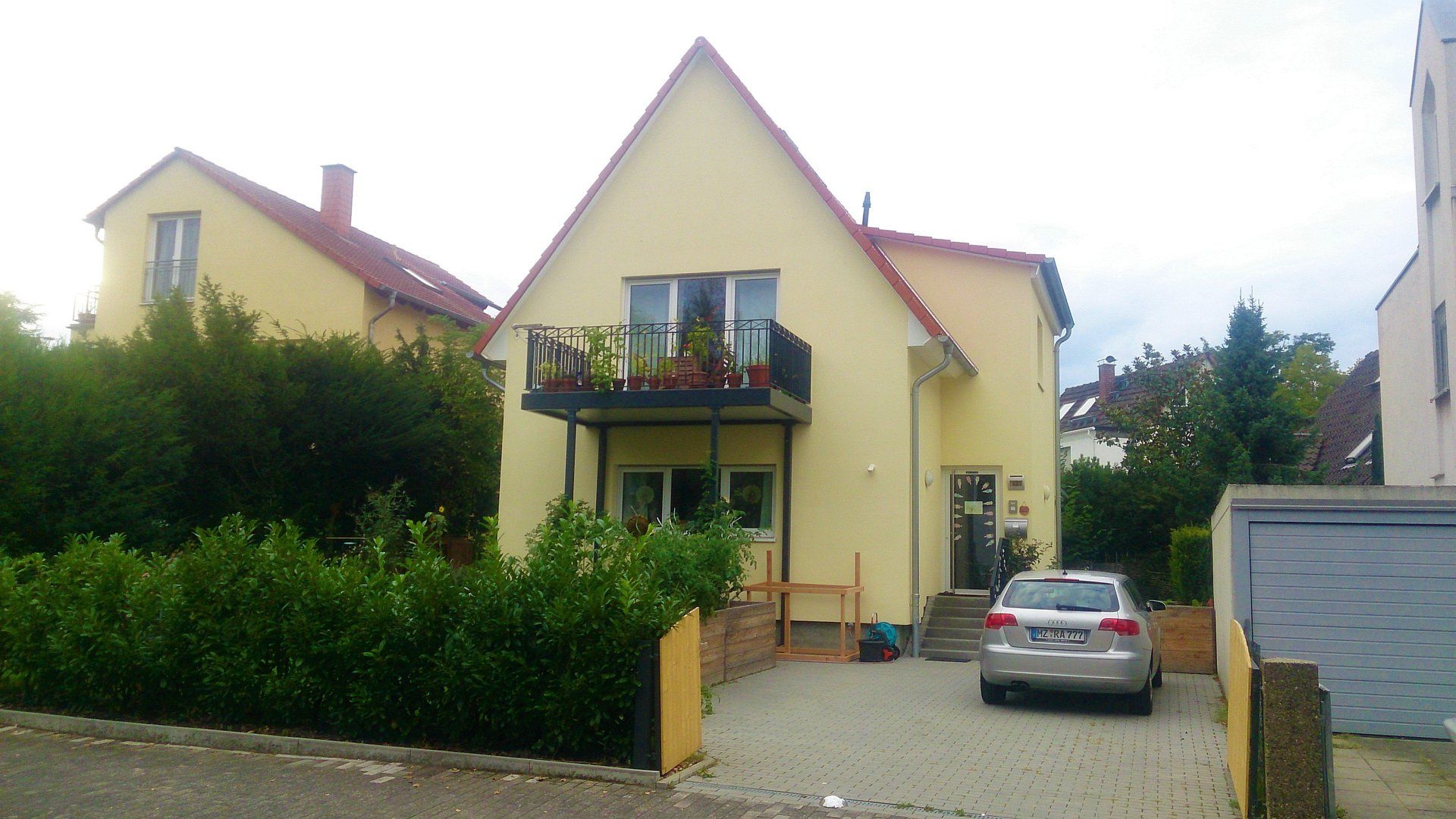 Ein Auto ist vor einem gelben Haus geparkt