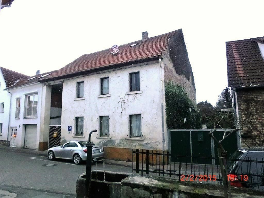 Ein silbernes Auto steht vor einem weißen Gebäude