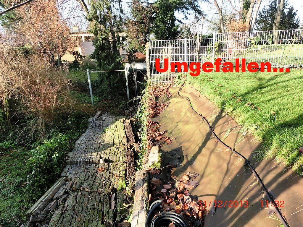 Mit einem Schlauch wird ein Abfluss in einem Hof ​​gereinigt.