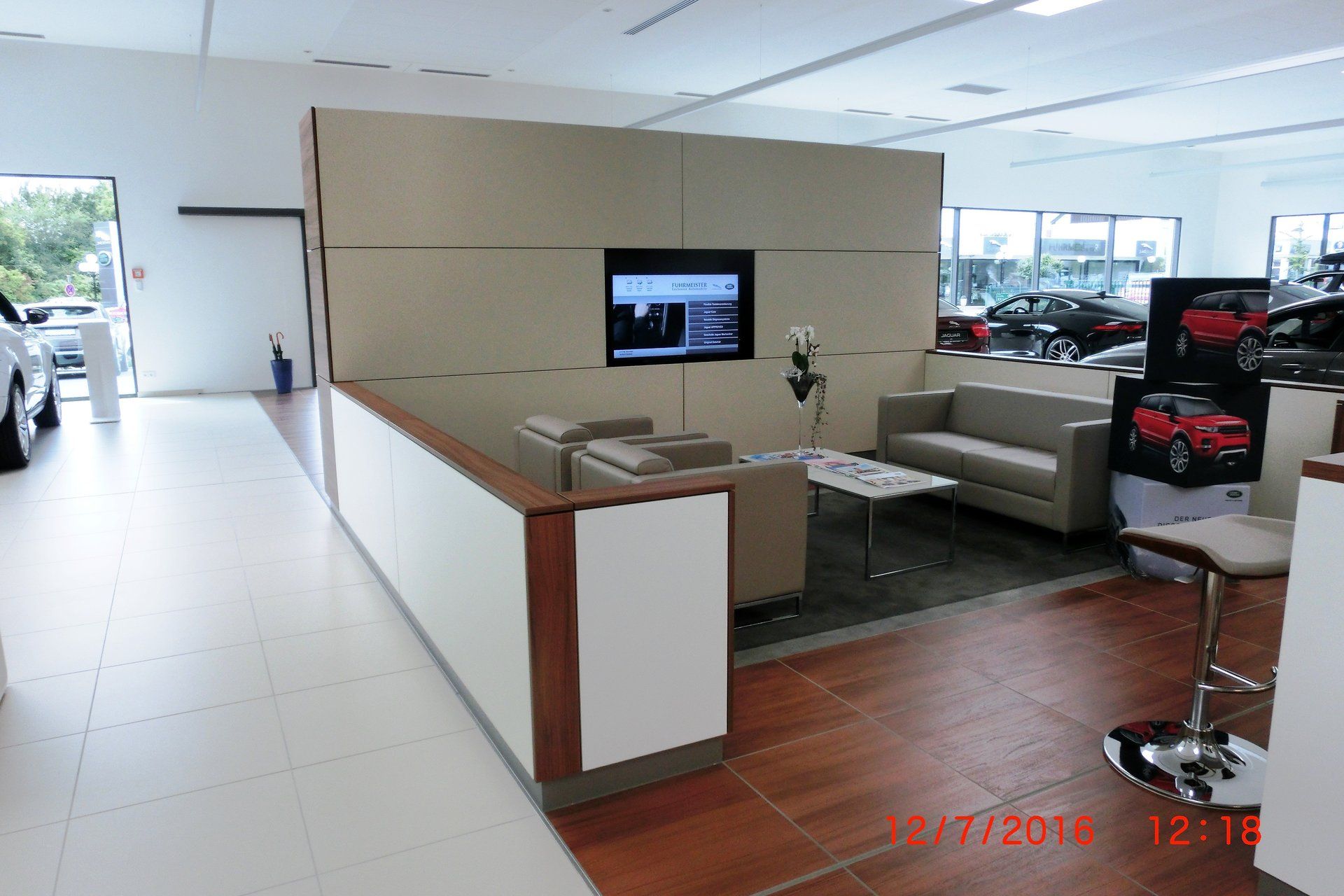 Ein Ausstellungsraum mit einer Couch und einem Fernseher an der Wand