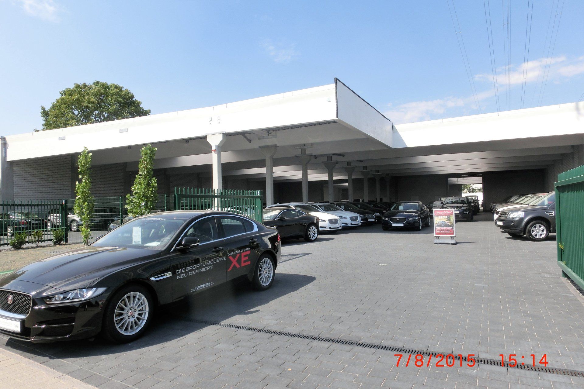 Ein schwarzes Auto steht vor einem Autohaus