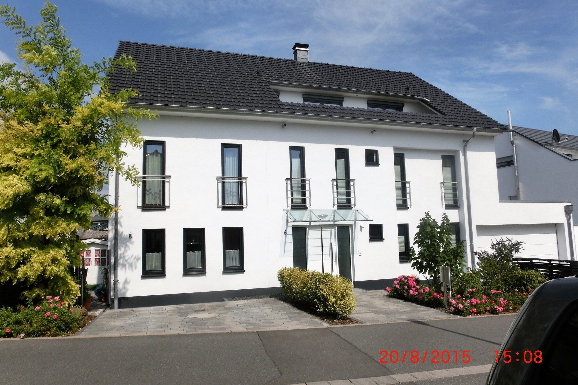 Ein großes weißes Gebäude mit einem schwarzen Dach