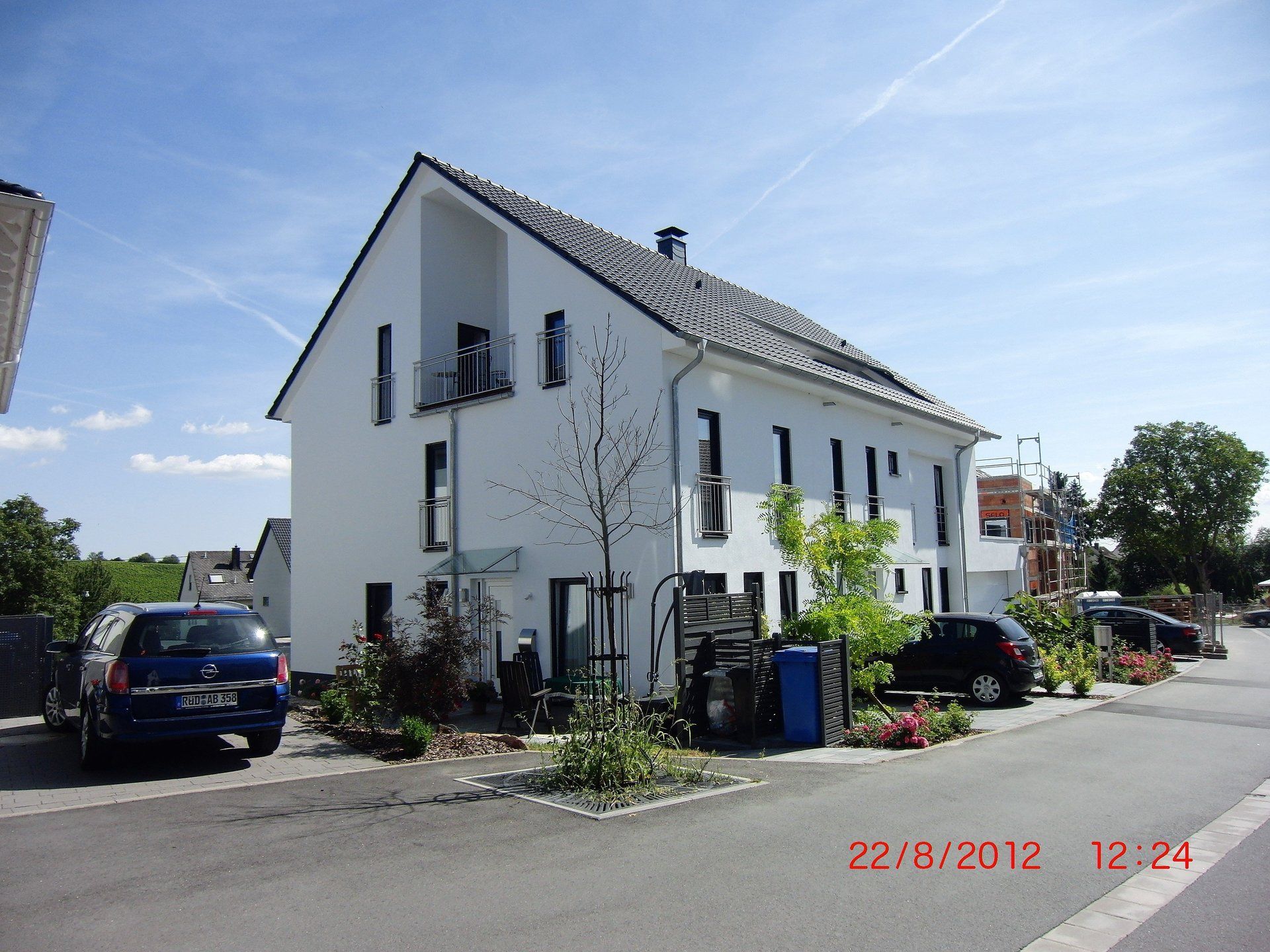 Ein blaues Auto steht vor einem weißen Haus