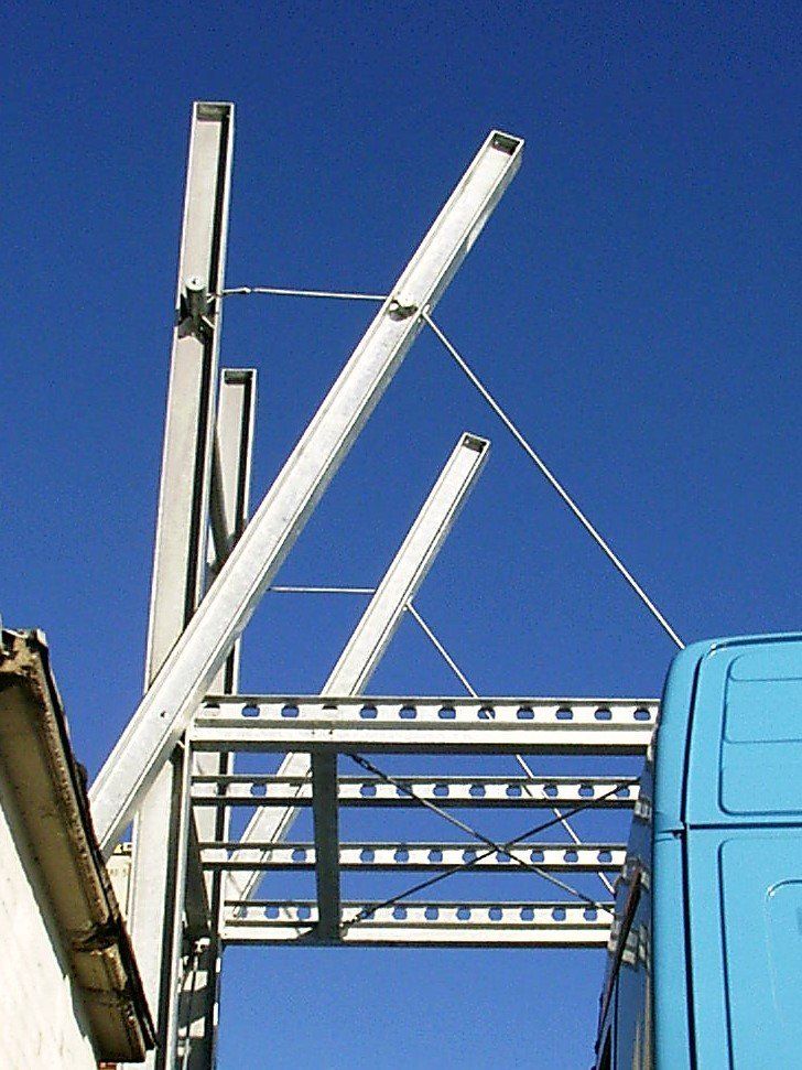 Ein blauer LKW ist unter einer Metallkonstruktion geparkt