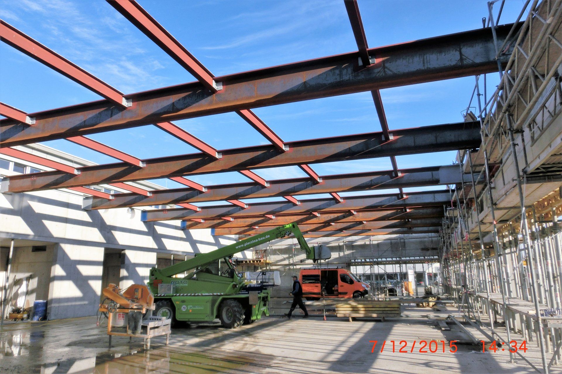 Ein grüner LKW steht vor einem im Bau befindlichen Gebäude
