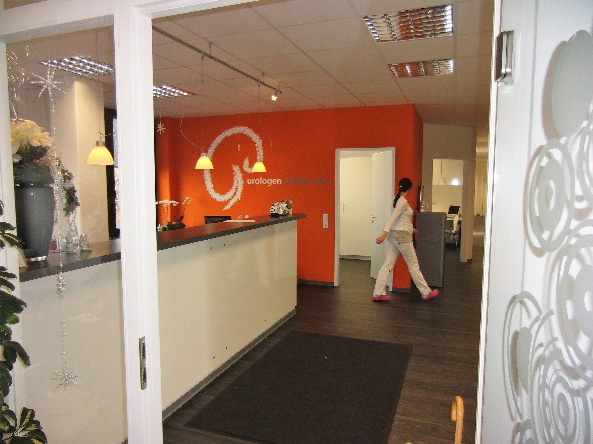 Eine Frau geht in einen Raum mit einer orangefarbenen Wand