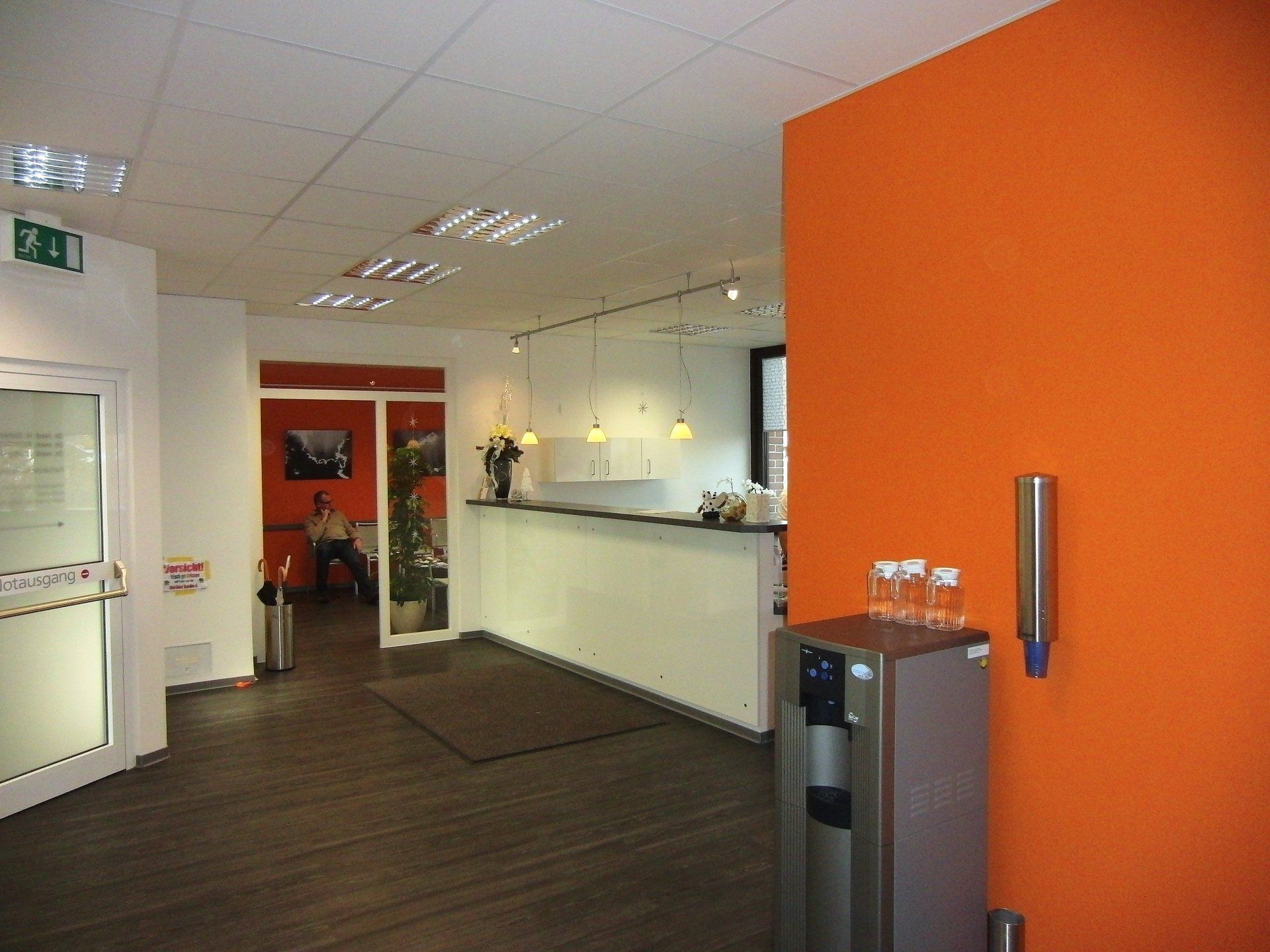 Ein Raum mit orangefarbenen Wänden und einem Wasserspender