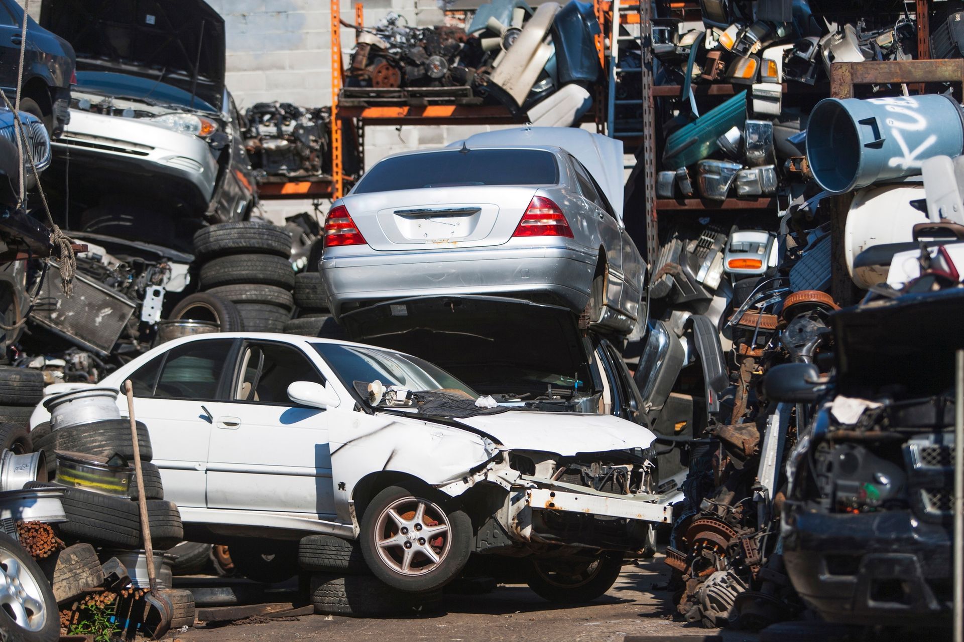 Old cars tightly packed in a junk yard waiting for parts removal or recycling.