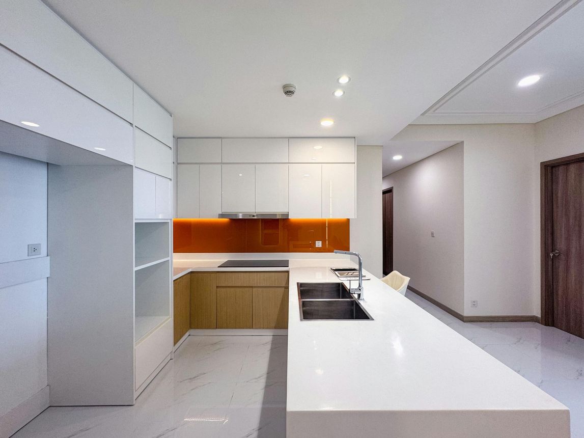 A kitchen with white cabinets , a sink and a stove.