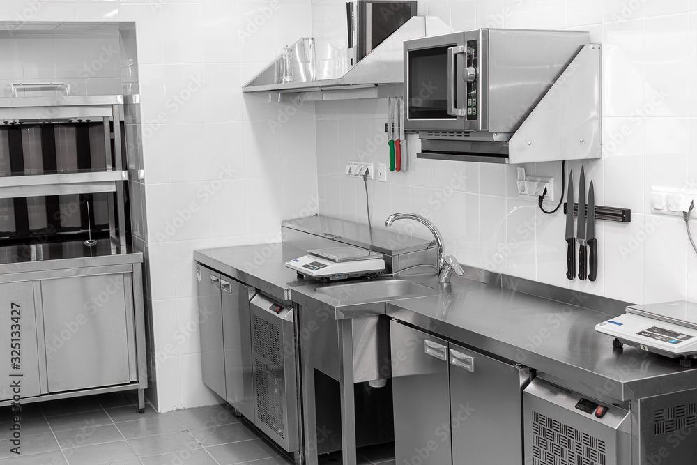 A black and white photo of a kitchen with stainless steel appliances.