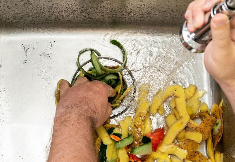 a person is washing vegetables in a sink .