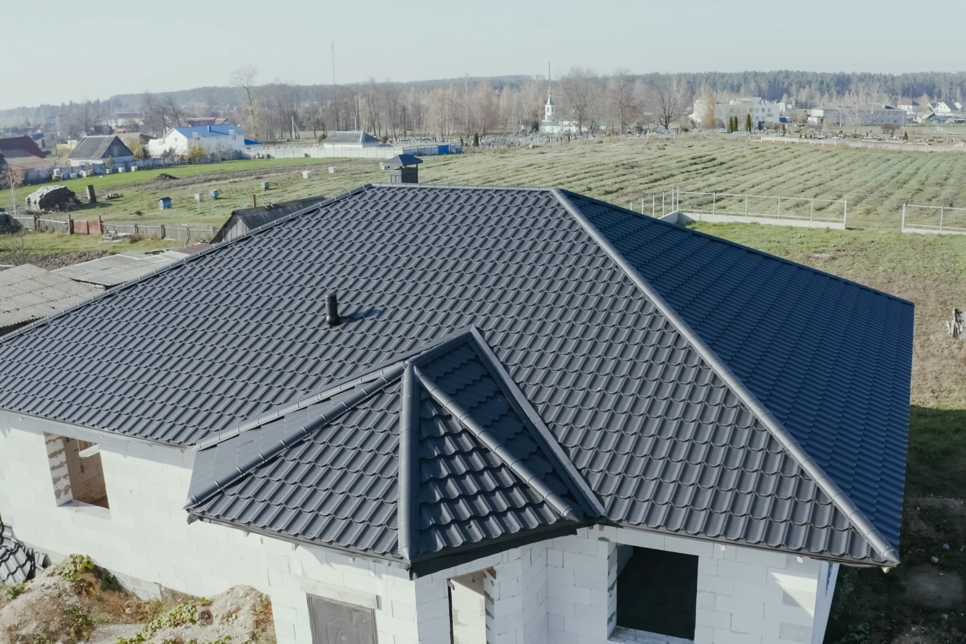 An aerial view of a house under construction with a black roof.
