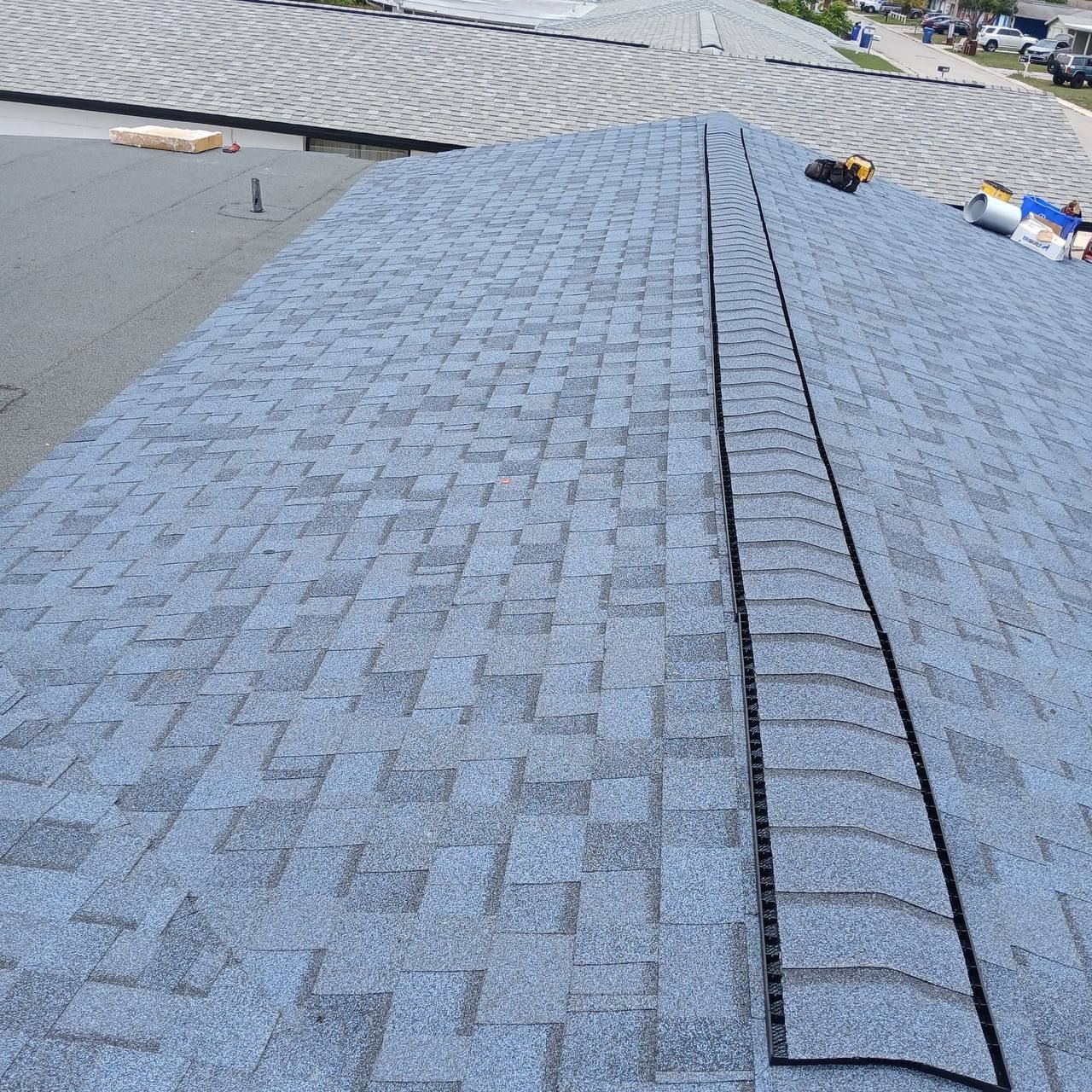 An aerial view of a house with a shingle roof and a window.