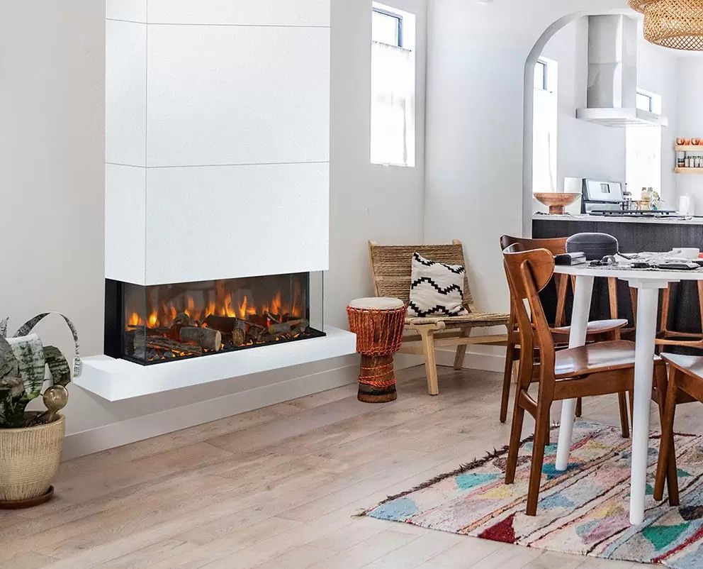 Moderno camino bianco in una luminosa sala da pranzo con sedie in legno, un tappeto e una finestra.