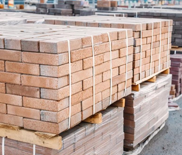 Attrezzi disposti su una superficie di legno: spazzole, guanti, seghe, martelli, un'ascia, pinze.