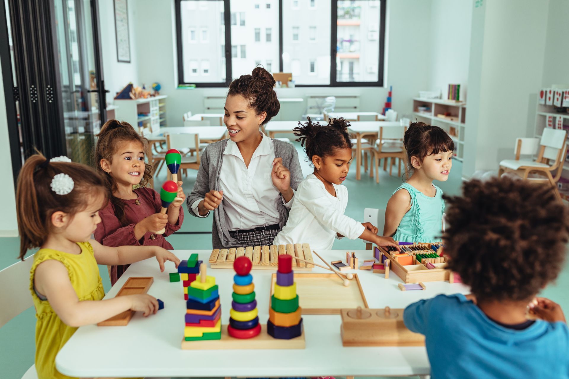 Children learning with a teacher using educational toys in a universal childcare classroom setting