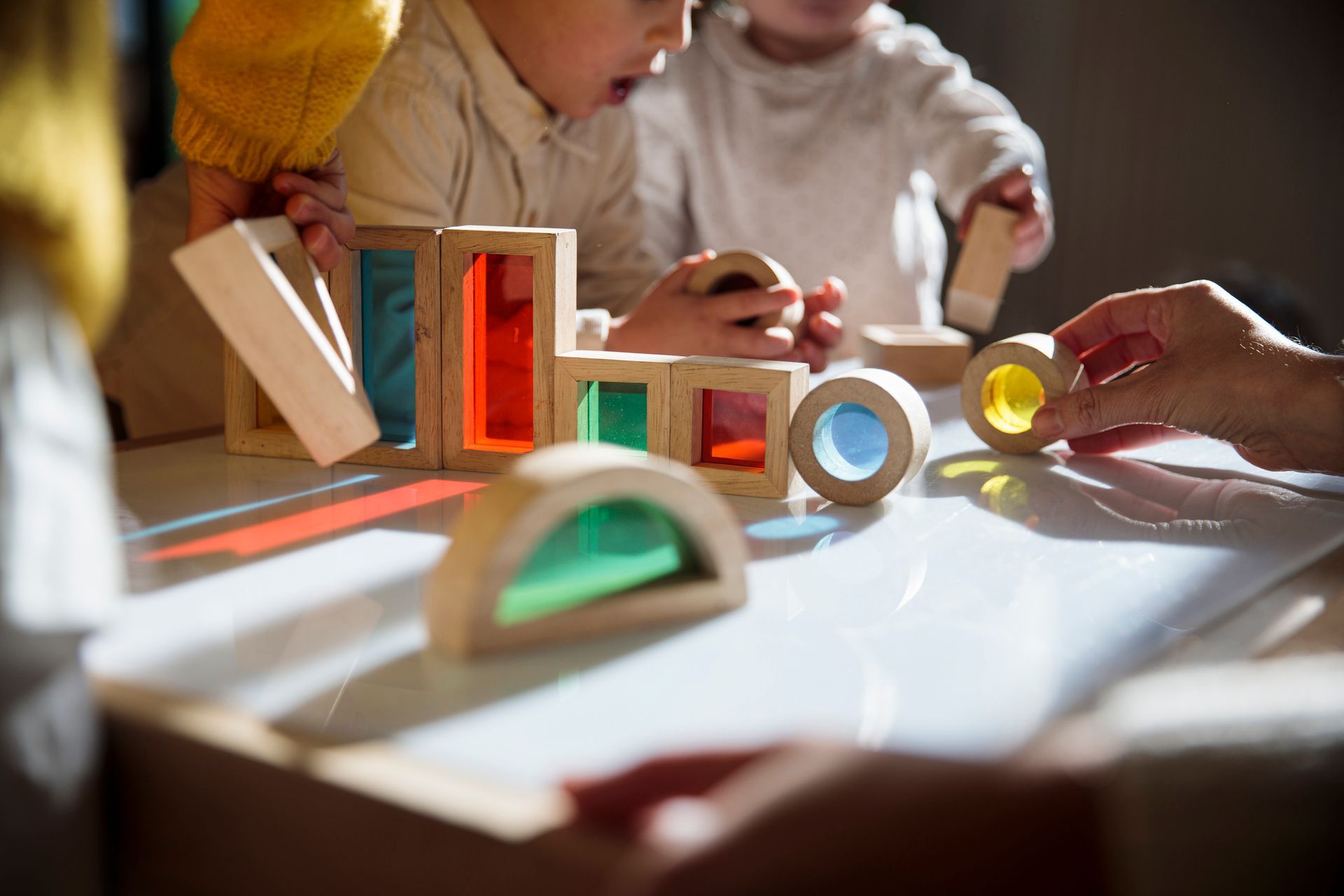 Children playing with colorful wooden blocks at a childcare center, promoting early childhood educat