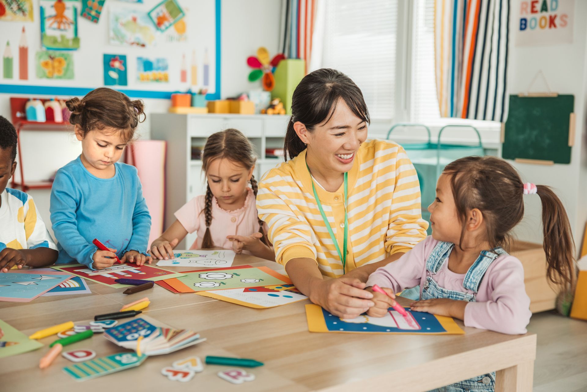 A smiling teacher is drawing with her students.  A smiling teacher is drawing with her students.