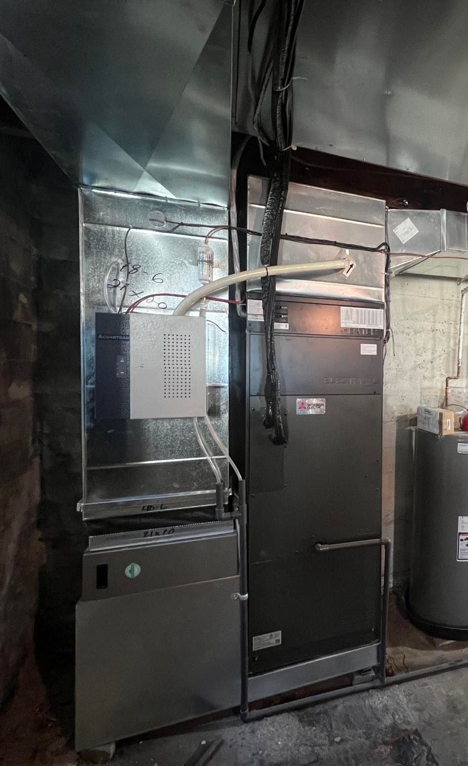 Une photo d'un système de chauffage et de climatisation dans un sous-sol.