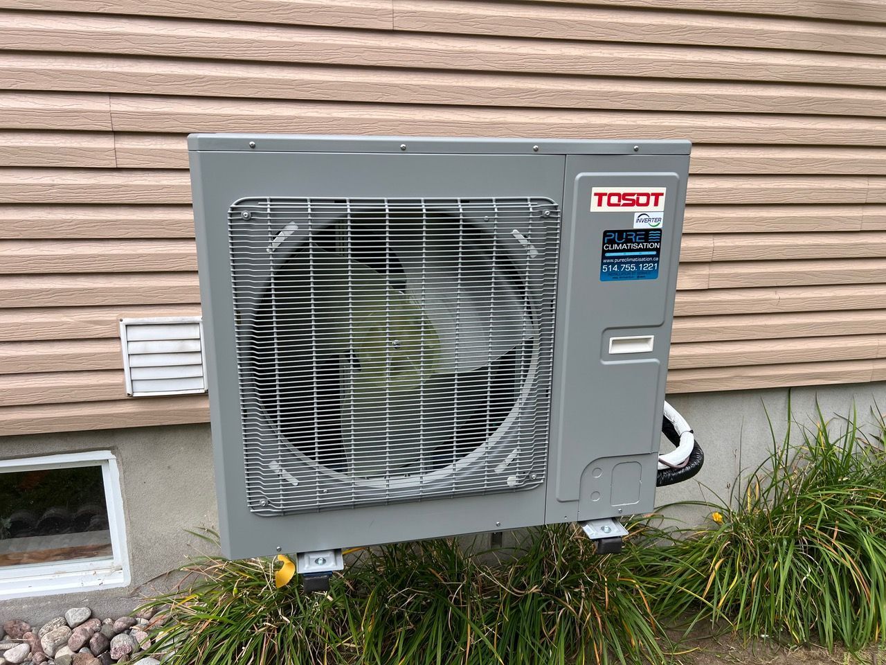Un climatiseur tosot est monté sur le côté d'une maison.