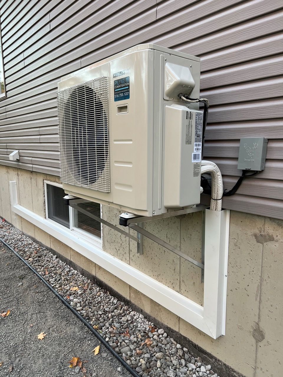 Un grand climatiseur est monté sur le côté d'une maison.