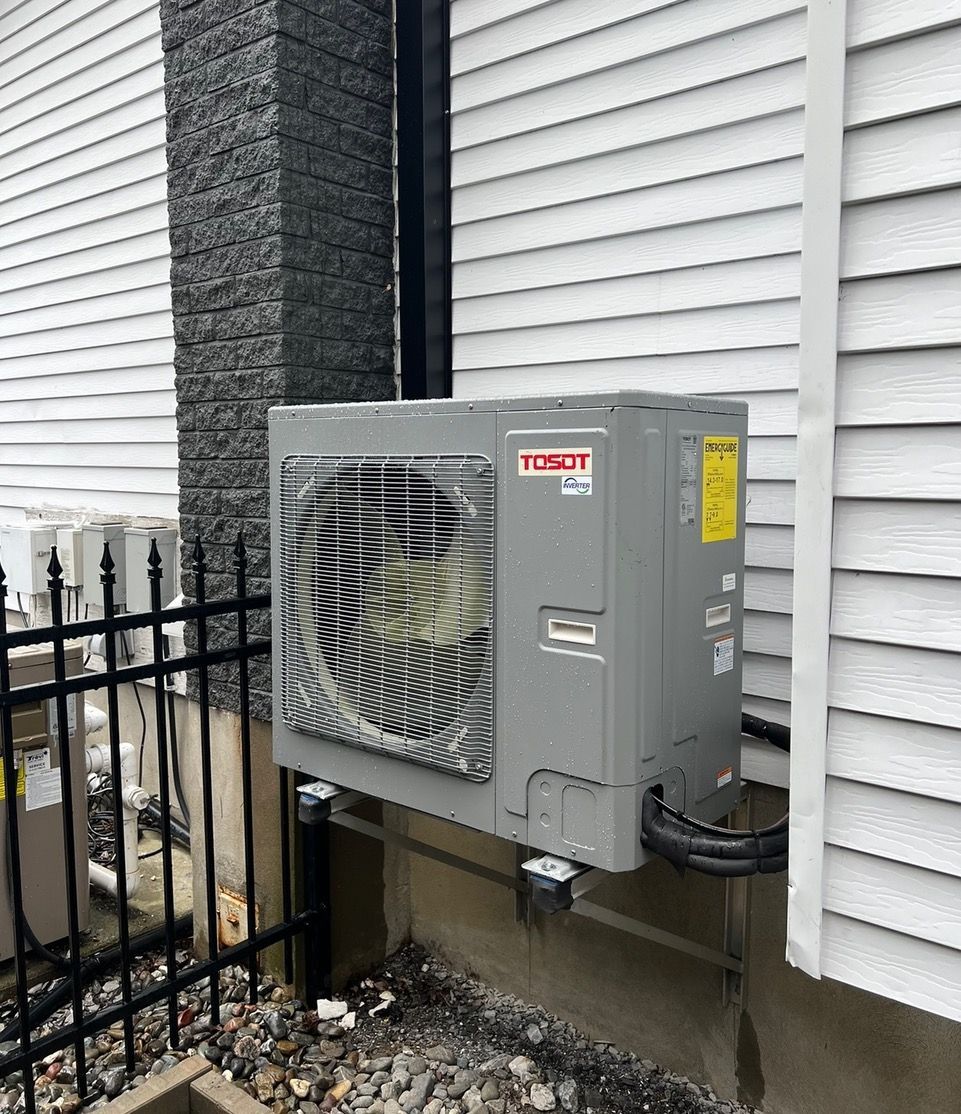 Un climatiseur Toshiba est installé sur le côté d'une maison.