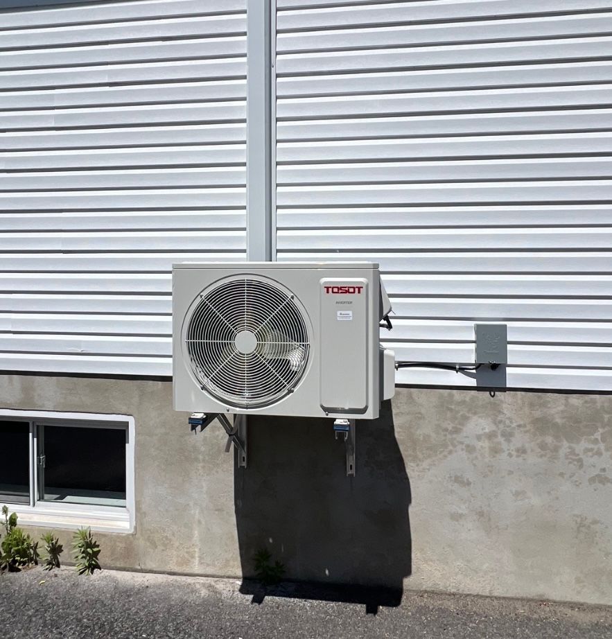 Un climatiseur toshut est monté sur le côté d'une maison