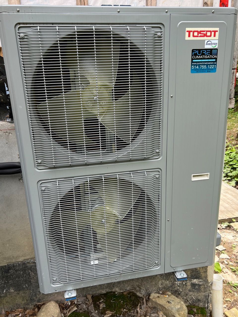 Un climatiseur tosot est posé sur le côté d'un bâtiment.