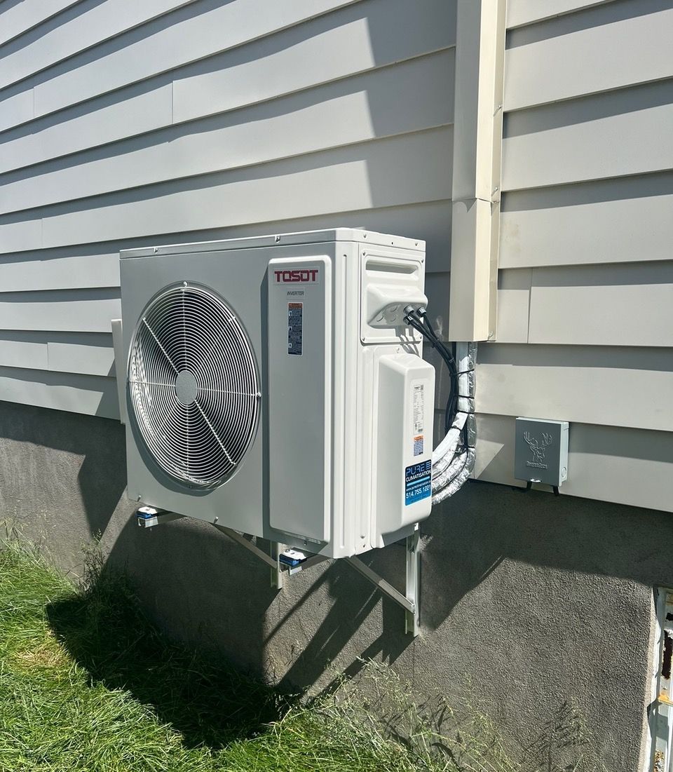Un climatiseur blanc est monté sur le côté d'une maison.
