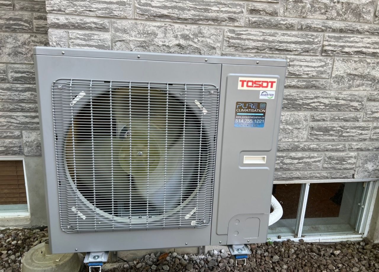 Un climatiseur robot est installé à l'extérieur d'un bâtiment en briques