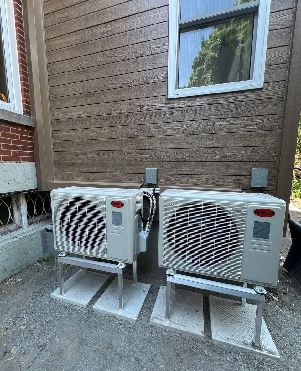 Deux climatiseurs sont installés sur le côté d'un bâtiment.