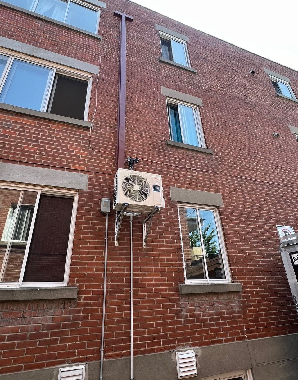 Un bâtiment en briques avec un ventilateur sur le côté.