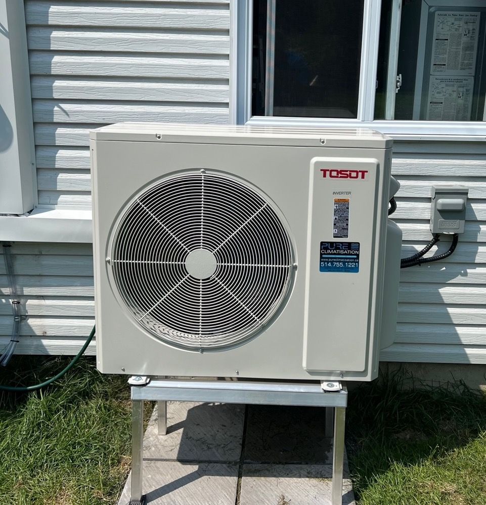 Un climatiseur tosot est installé à l'extérieur d'une maison