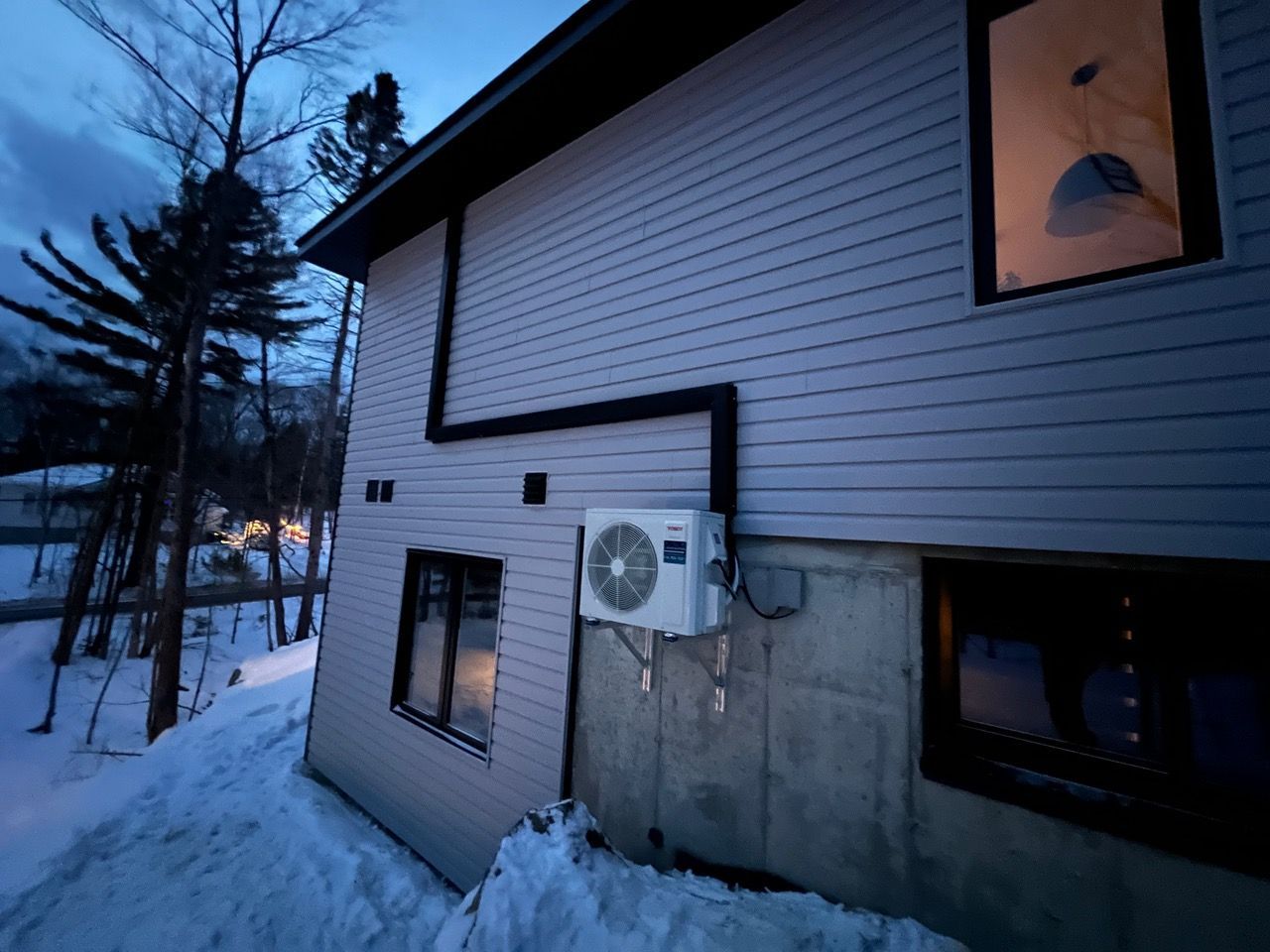 Une maison avec un climatiseur sur le côté