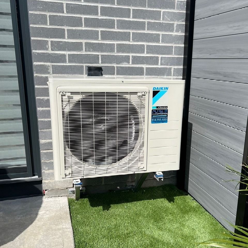 Un climatiseur Daikin est monté sur le côté d'un bâtiment en briques.