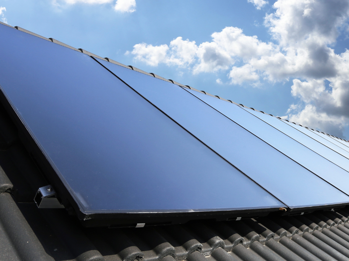 Er liggen veel zonnepanelen op het dak van een gebouw.
