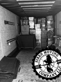 Interior of a truck loaded with packed boxes; Siren Moving Company logo.